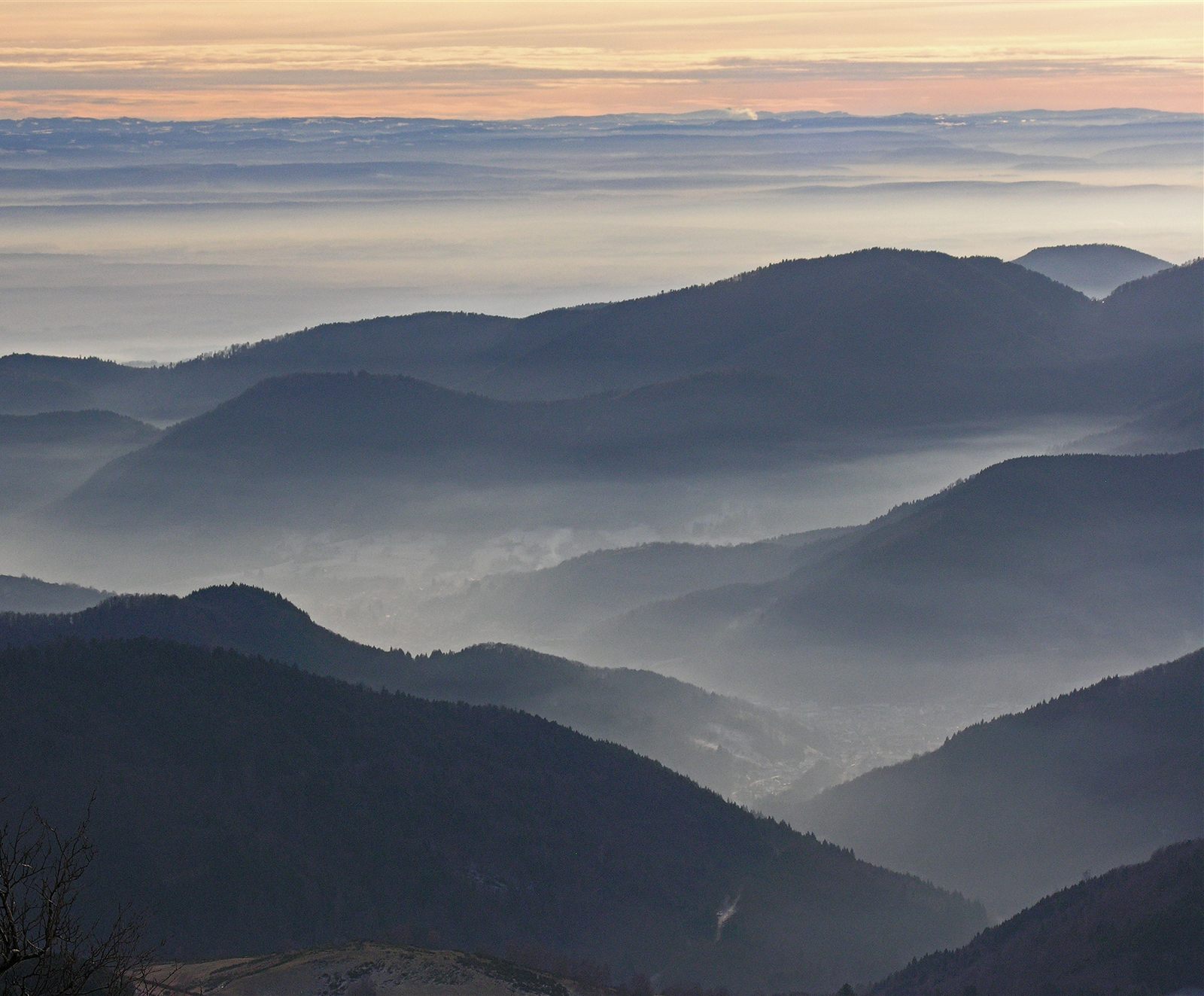 Vue panoramique des montagnes des Vosges sous la brume au lever du soleil — métaphore des pièges patrimoniaux à éviter par manque de visibilité