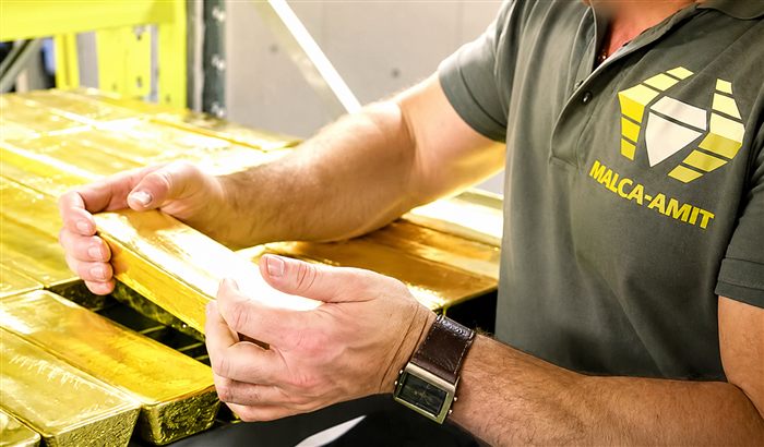 Employé Malca-Amit vérifiant des lingots d'or dans un entrepôt sécurisé