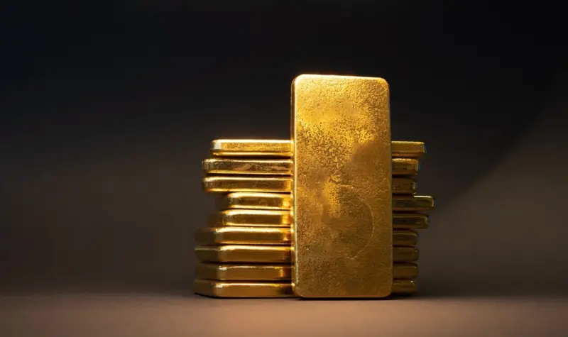 Lingot d'or debout devant une pile de lingots en clair-obscur — investissement premium