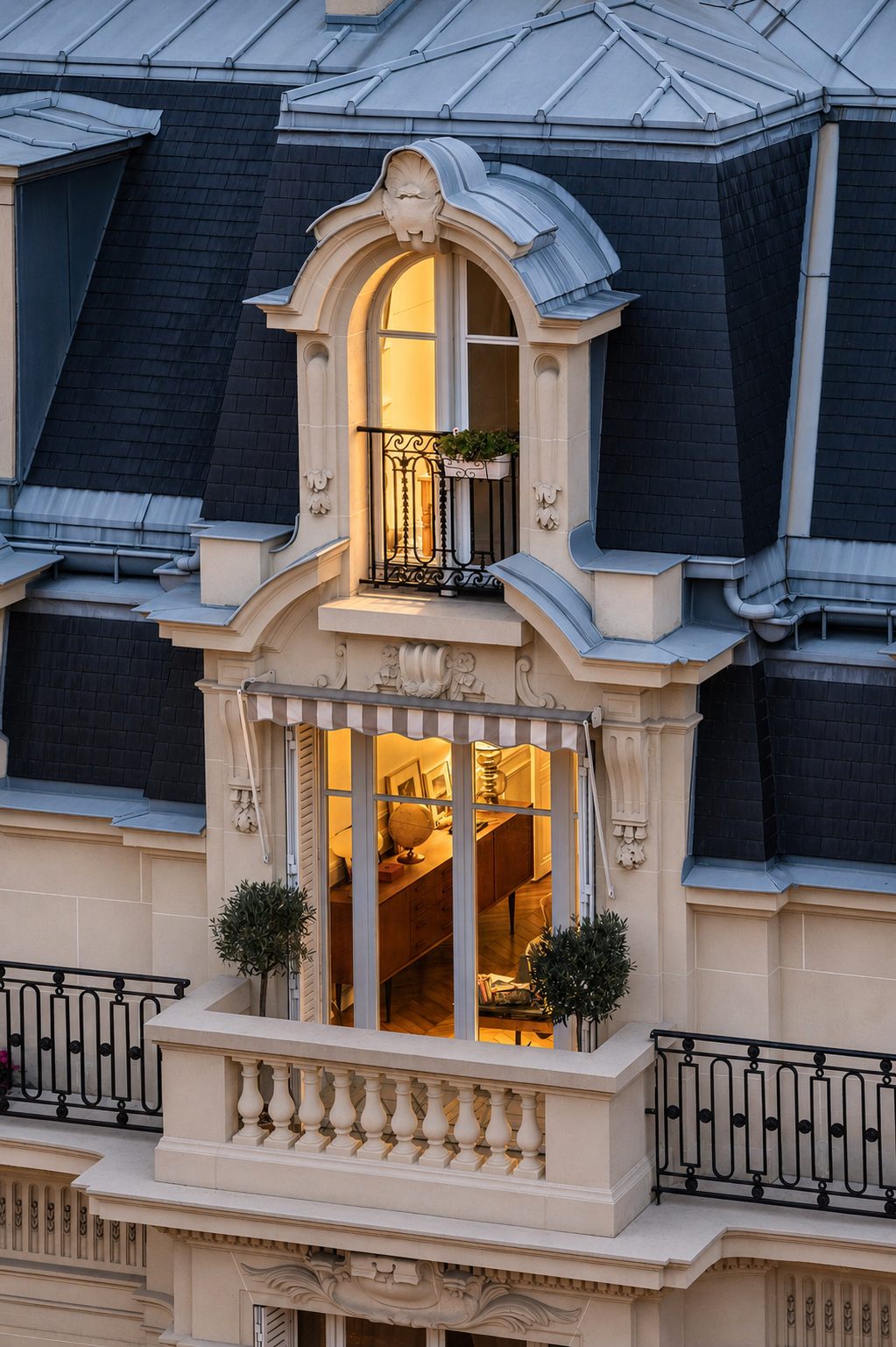 Duplex haussmannien parisien éclairé avec lucarne ornée, balcon en fer forgé et oliviers en pots — immobilier locatif de propriétaire bailleur de prestige