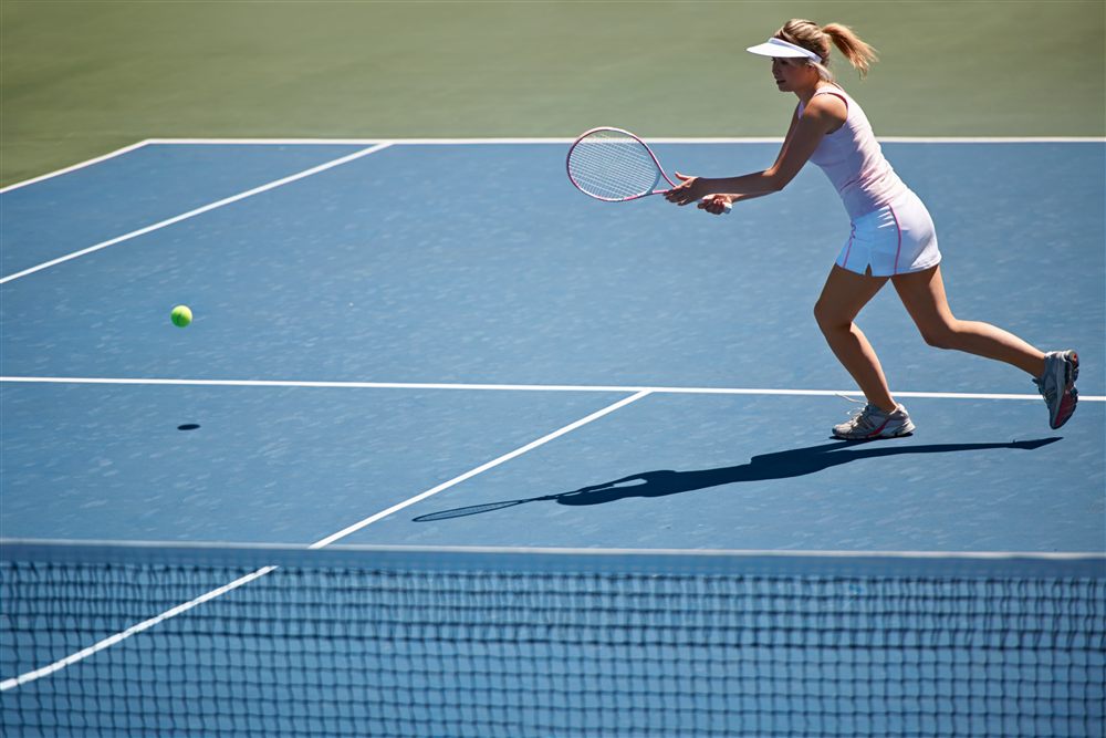Joueuse de tennis professionnelle en action sur un terrain en dur — sport de haut niveau et exigence physique